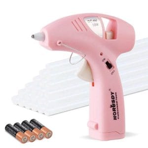 A cordless pink glue gun with batteries and a charger, perfect for crafting and DIY projects.